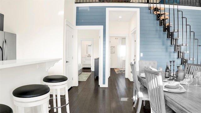 dining area with dark hardwood / wood-style flooring and a high ceiling