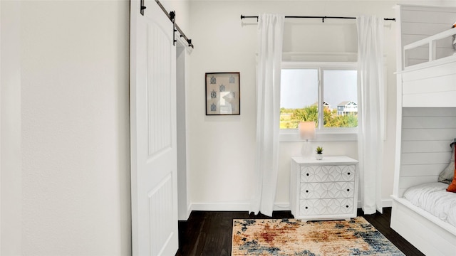 interior space with a barn door and dark hardwood / wood-style floors