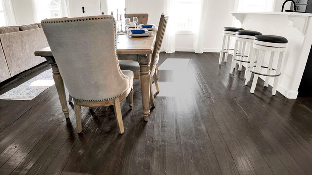 dining area featuring dark wood-type flooring and sink