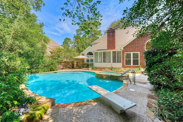 view of pool featuring an in ground hot tub, a diving board, a patio area, and a sunroom