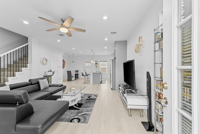 living room featuring ceiling fan and light hardwood / wood-style flooring