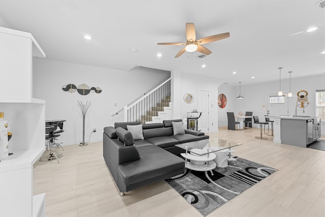 living room featuring light wood-type flooring and ceiling fan