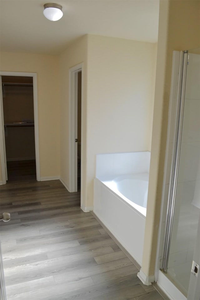 bathroom with hardwood / wood-style floors and independent shower and bath