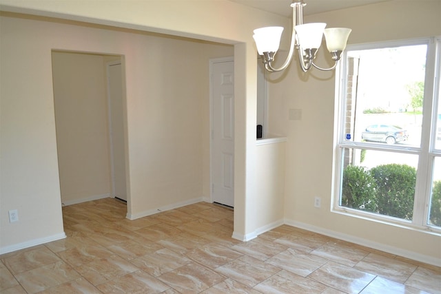 unfurnished room with an inviting chandelier