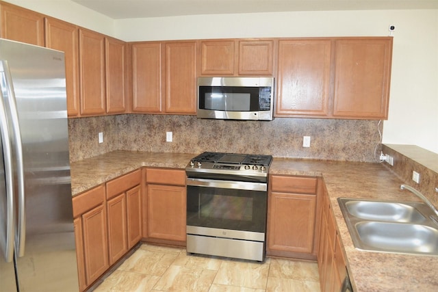 kitchen featuring decorative backsplash, stainless steel appliances, and sink