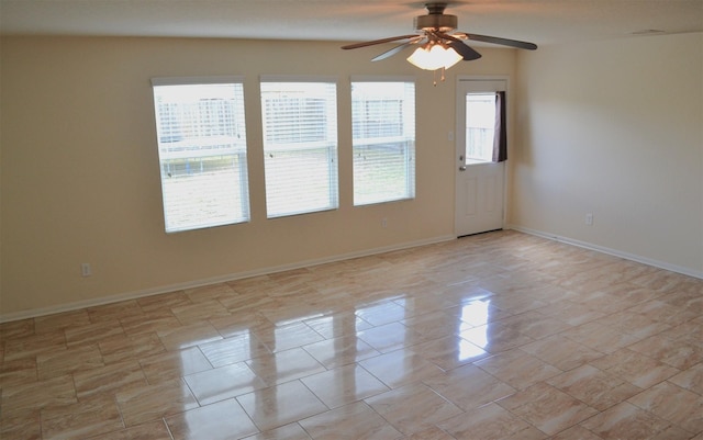 tiled spare room featuring ceiling fan