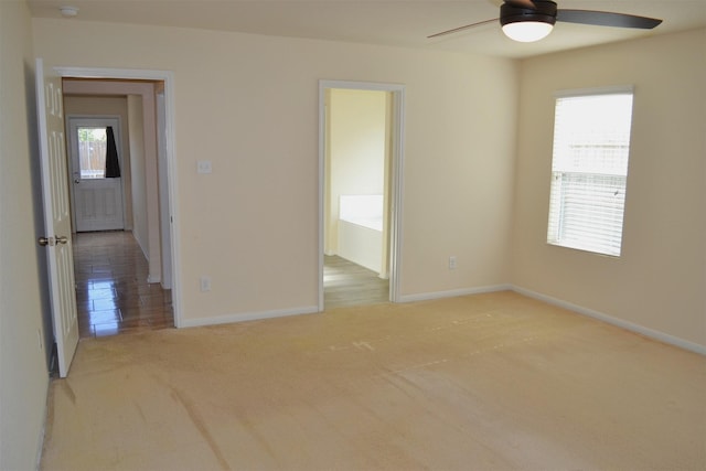 spare room with ceiling fan and light colored carpet