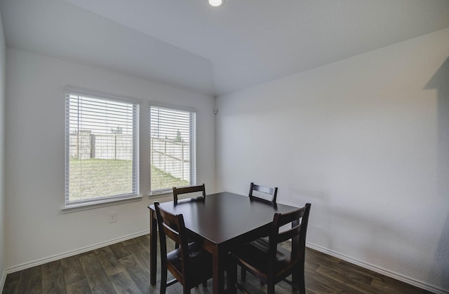 dining area featuring dark hardwood / wood-style flooring and vaulted ceiling