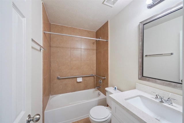 full bathroom featuring tiled shower / bath combo, tile patterned floors, a textured ceiling, toilet, and vanity