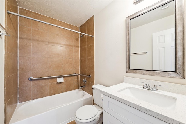 full bathroom with vanity, a textured ceiling, toilet, and tiled shower / bath