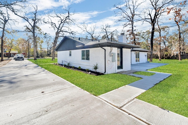 view of side of home featuring a carport and a yard