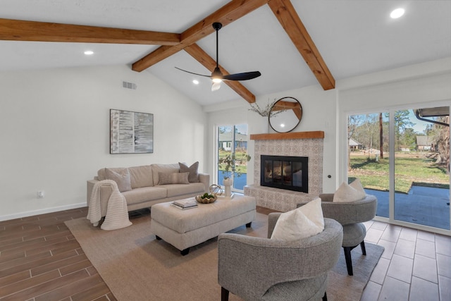 living room with vaulted ceiling with beams, ceiling fan, and a fireplace