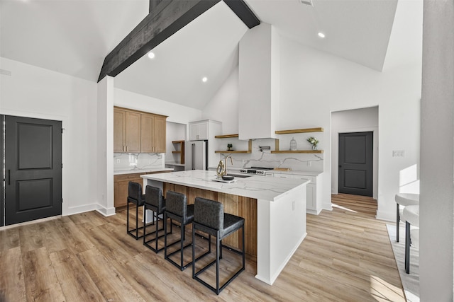 kitchen with a breakfast bar area, backsplash, a center island, and high vaulted ceiling