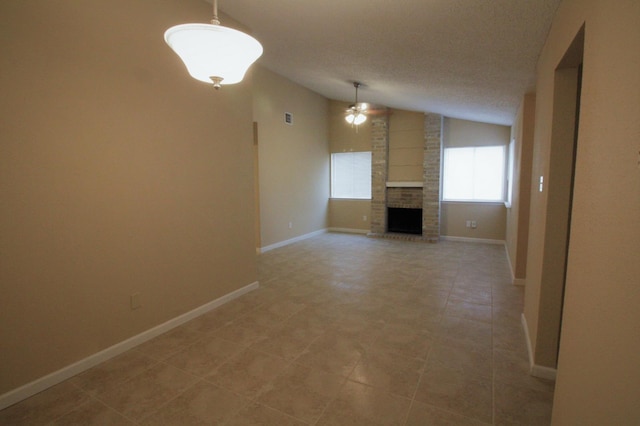 unfurnished living room featuring a textured ceiling, lofted ceiling, and a fireplace