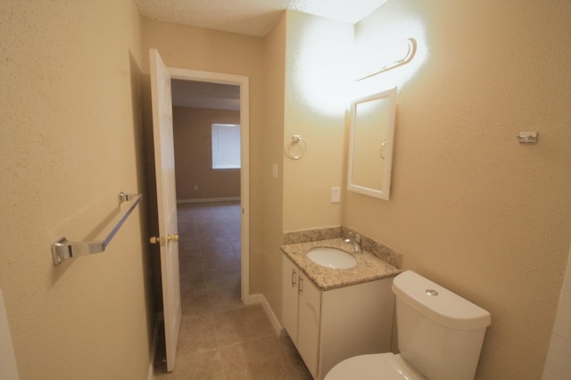 bathroom featuring a textured ceiling, vanity, and toilet