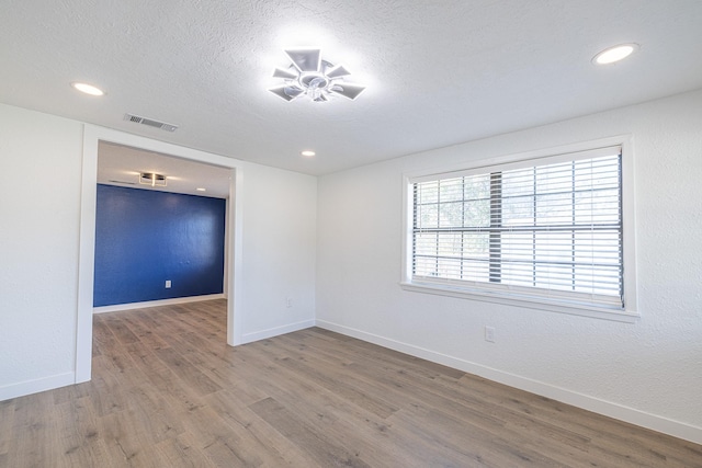 unfurnished room featuring ceiling fan, hardwood / wood-style floors, and a textured ceiling