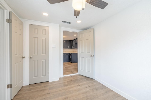 unfurnished bedroom with ceiling fan, a closet, and light wood-type flooring