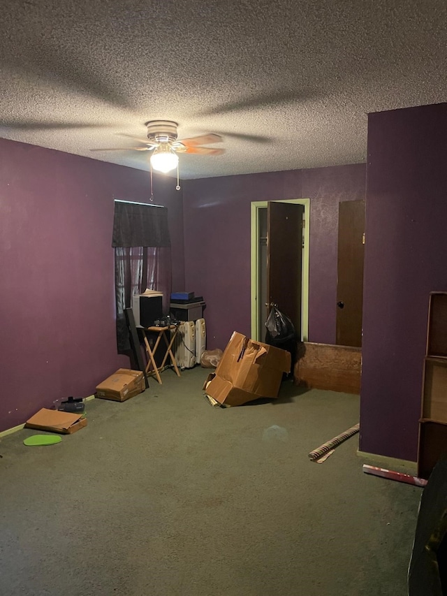 miscellaneous room featuring a textured ceiling, carpet floors, and ceiling fan