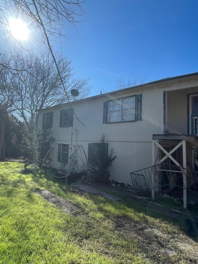 view of side of home with a lawn