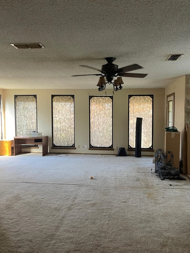 interior space with carpet flooring, ceiling fan, and a textured ceiling