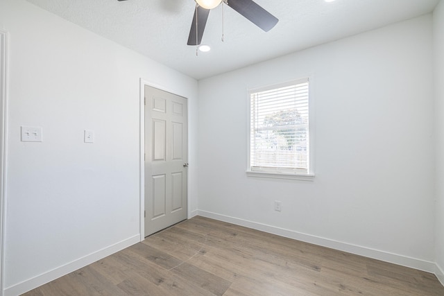 unfurnished room featuring a textured ceiling, light hardwood / wood-style flooring, and ceiling fan