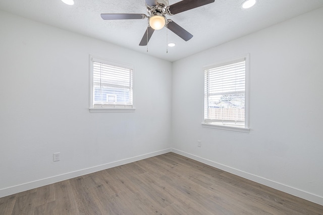 empty room featuring hardwood / wood-style floors, a wealth of natural light, and ceiling fan