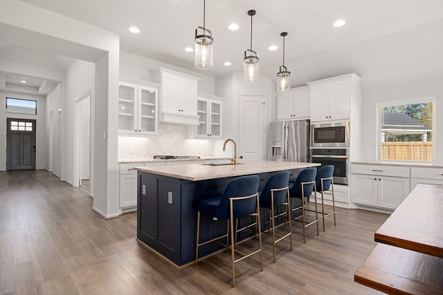 kitchen with white cabinets, sink, an island with sink, and appliances with stainless steel finishes