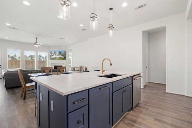 kitchen featuring pendant lighting, a center island with sink, sink, ceiling fan, and dark hardwood / wood-style floors