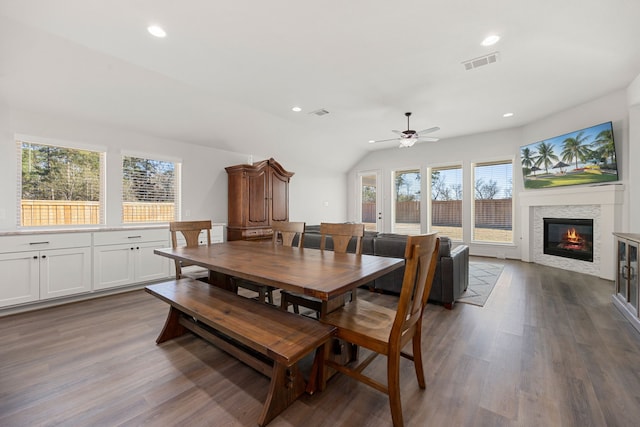 dining space with hardwood / wood-style floors, ceiling fan, and lofted ceiling