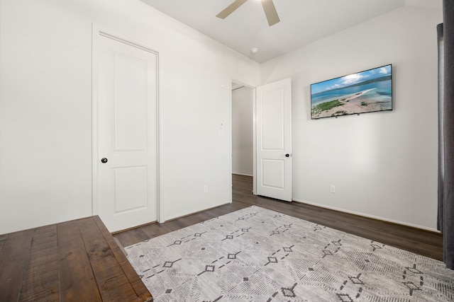 unfurnished bedroom featuring ceiling fan and dark wood-type flooring