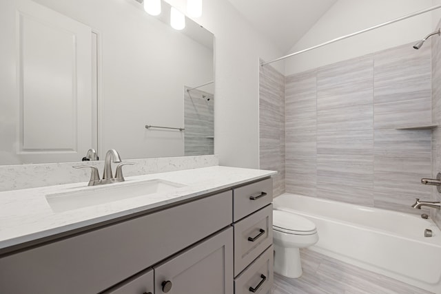 full bathroom featuring vanity, toilet, tiled shower / bath, and vaulted ceiling