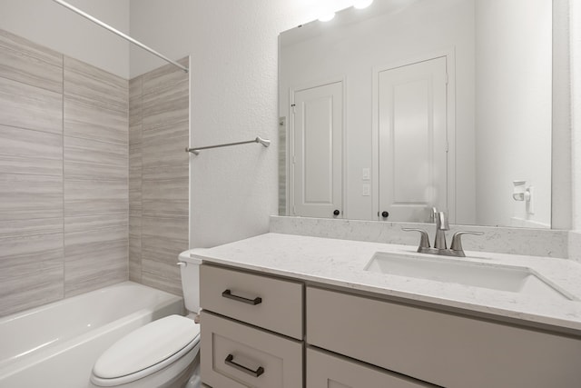 full bathroom featuring tiled shower / bath, vanity, and toilet