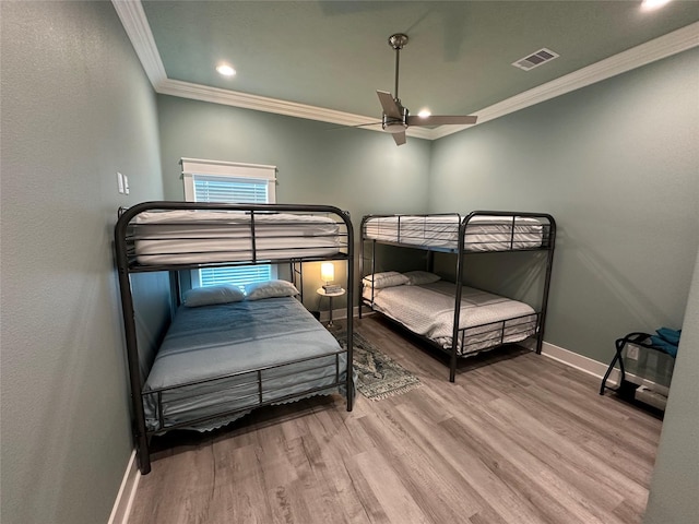 bedroom with hardwood / wood-style floors, ceiling fan, and ornamental molding