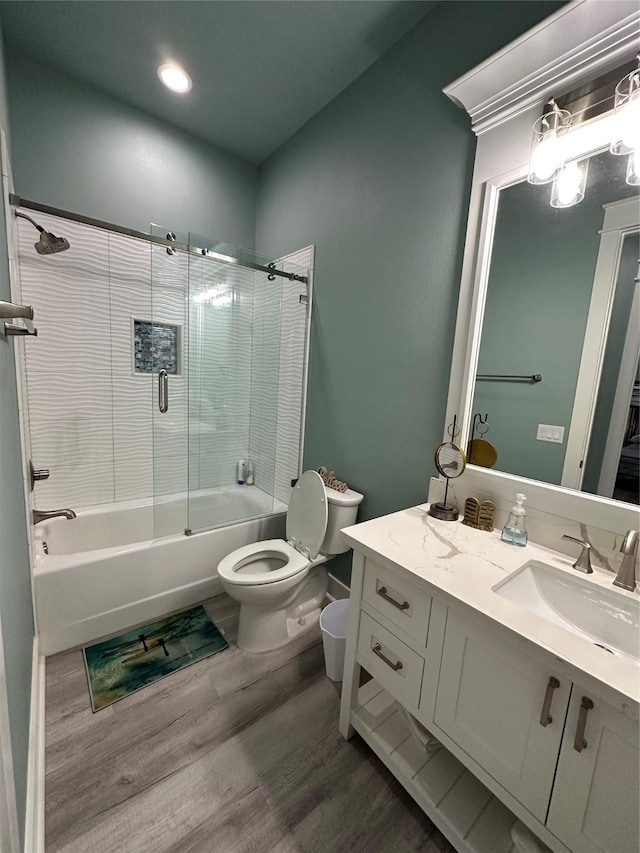 full bathroom featuring toilet, vanity, combined bath / shower with glass door, and hardwood / wood-style flooring