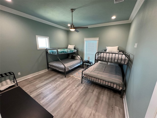 bedroom featuring hardwood / wood-style floors, ceiling fan, and ornamental molding