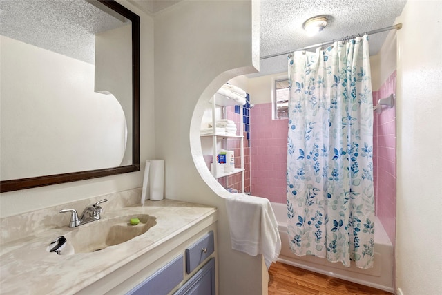 bathroom with vanity, wood-type flooring, shower / bathtub combination with curtain, and a textured ceiling