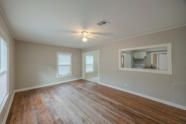 1202 14th Ave N, Texas City, TX 77590 - unfurnished room with ceiling fan, wooden walls, wood-type flooring, and ornamental molding