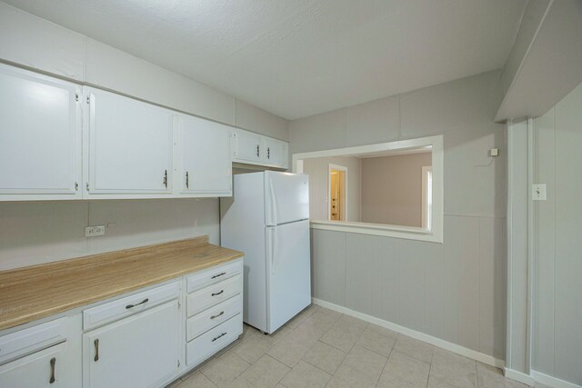 1202 14th Ave N, Texas City, TX 77590 - kitchen featuring white refrigerator, white cabinetry, and a textured ceiling