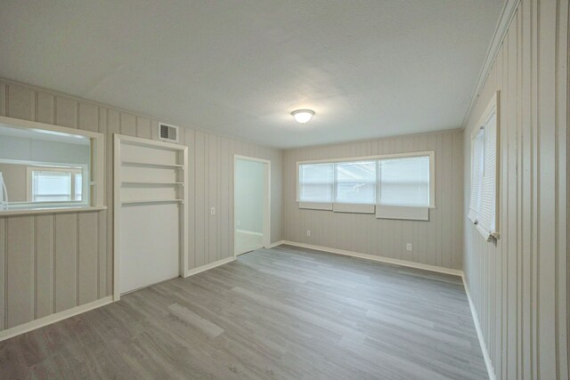 1202 14th Ave N, Texas City, TX 77590 - unfurnished bedroom with a textured ceiling and light hardwood / wood-style floors