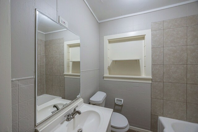 1202 14th Ave N, Texas City, TX 77590 - bathroom featuring a bathtub, sink, toilet, ornamental molding, and tile walls