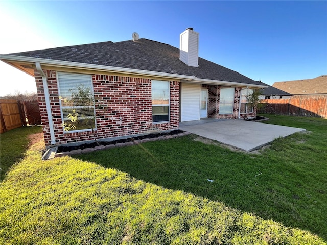 back of property with a lawn and a patio area