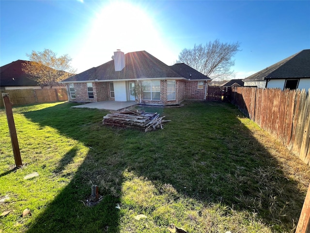 back of property with a lawn and a patio area