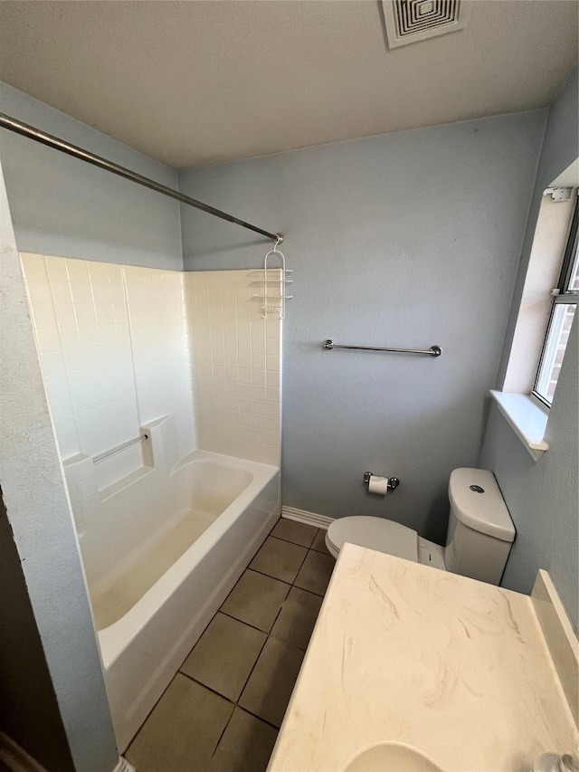 bathroom featuring washtub / shower combination, tile patterned floors, and toilet