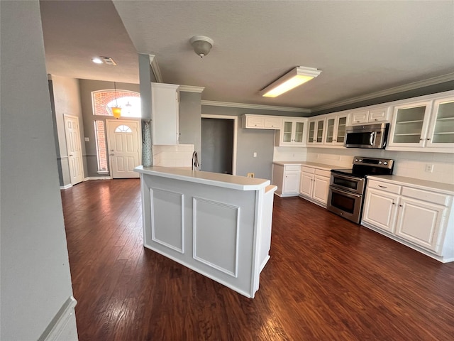 kitchen with backsplash, stainless steel appliances, white cabinets, dark hardwood / wood-style flooring, and kitchen peninsula