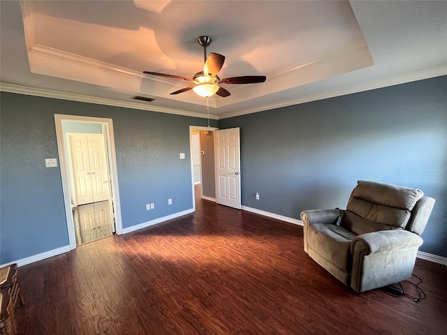 unfurnished room featuring ornamental molding, dark hardwood / wood-style floors, ceiling fan, and a tray ceiling