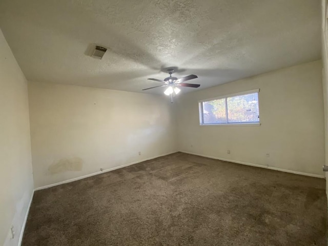 spare room with ceiling fan, a textured ceiling, and dark colored carpet