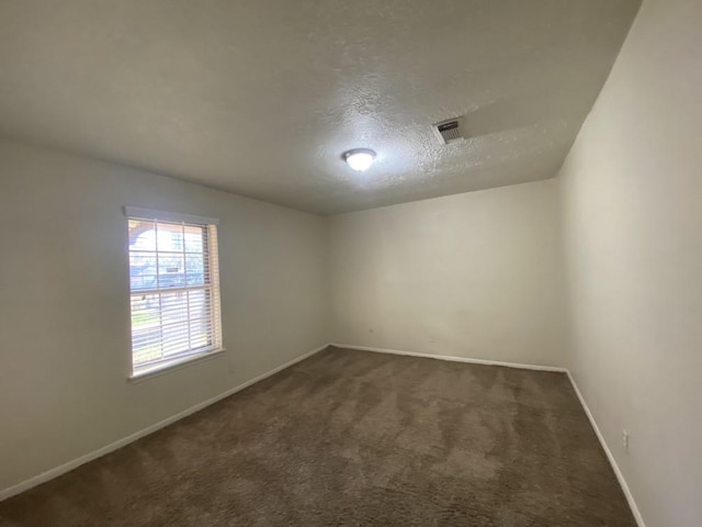 carpeted spare room with a textured ceiling