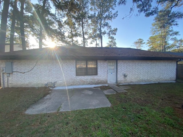 rear view of property featuring a yard and a patio