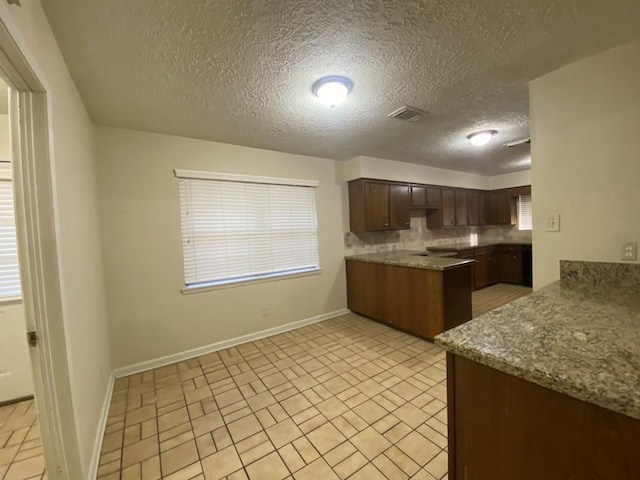 kitchen with decorative backsplash, dark brown cabinets, and a textured ceiling