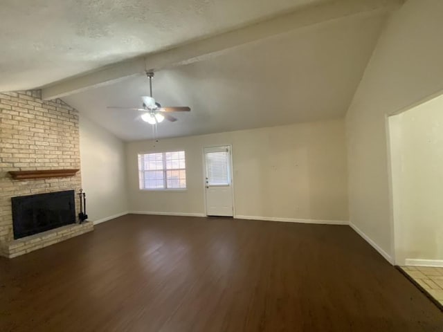 unfurnished living room featuring ceiling fan, a brick fireplace, vaulted ceiling with beams, dark hardwood / wood-style floors, and a textured ceiling